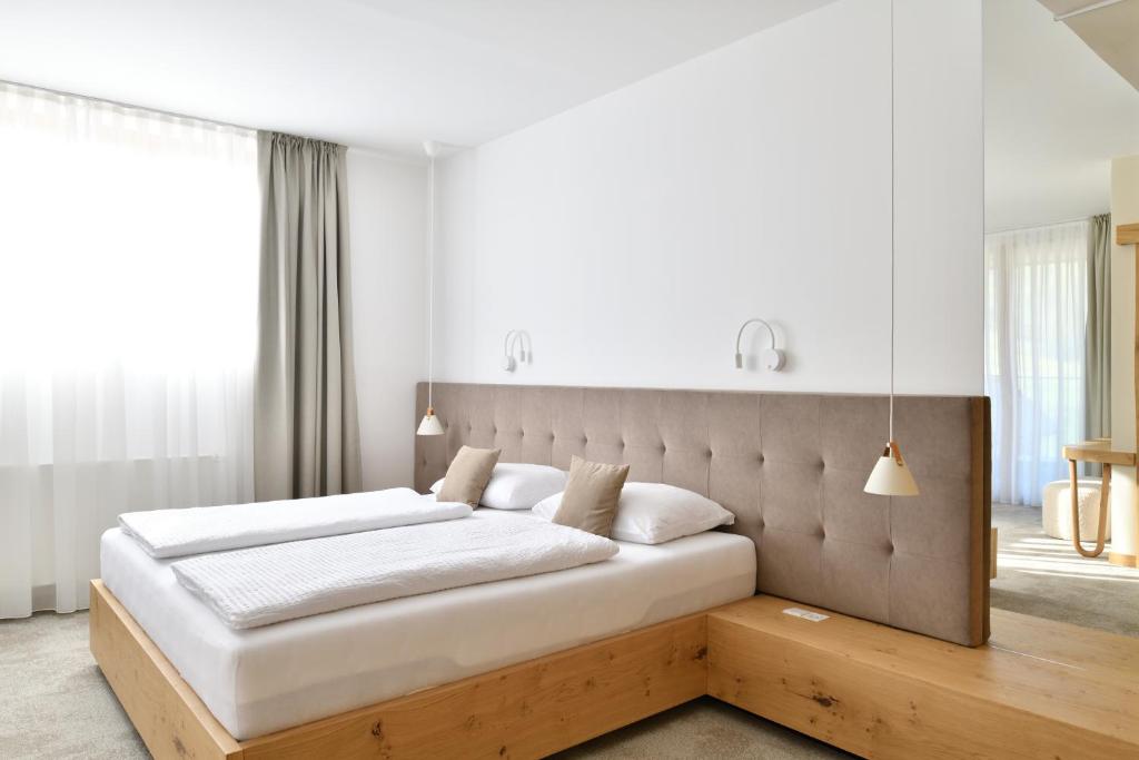 Zgornja Kungota的住宿－維拉馳科旅館，一间卧室配有一张大床和木制床头板