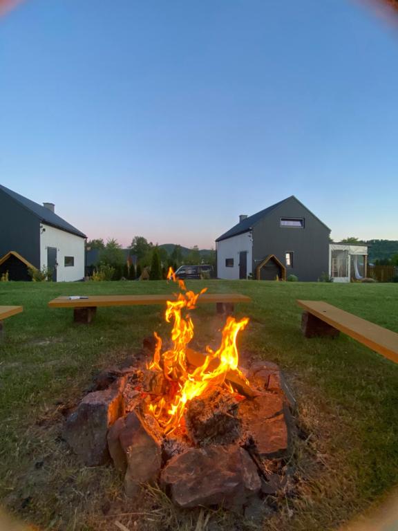 a fire pit in the middle of a yard at Bieszczadzkie BOHO stodoły z jacuzzi i sauna na wyłączność in Myczkowce