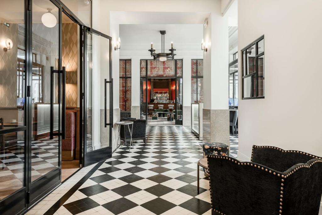 a hallway with a black and white checkered floor at Hôtel de la Poste in Beaune