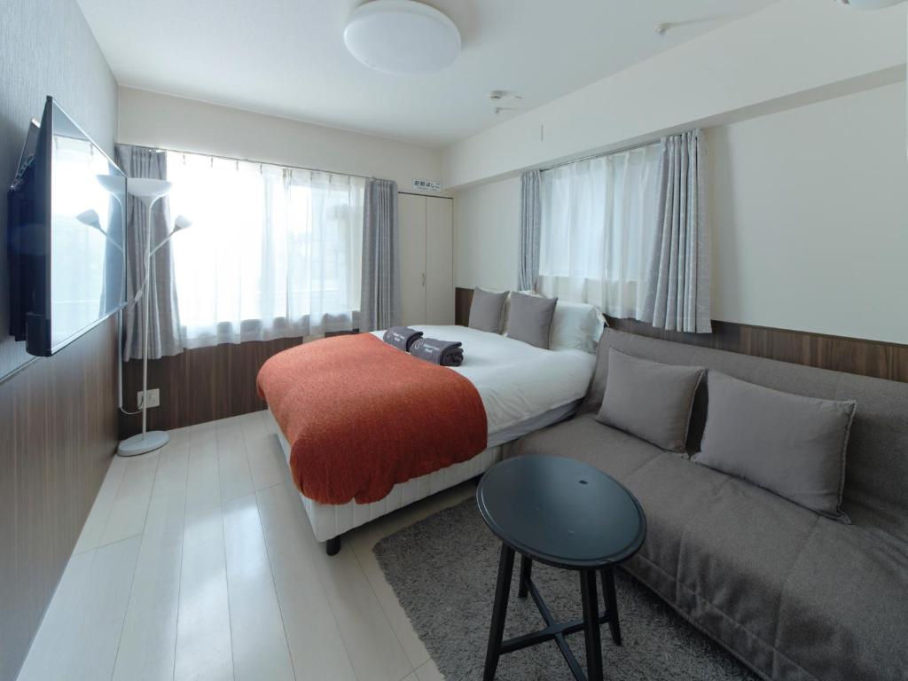 una habitación de hotel con una cama y un sofá en Sakura Cross Hotel Ueno Iriya, en Tokio