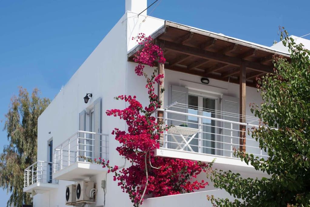 a white house with flowers on the balcony at Paros Hospitality by the sea in Kampos Paros
