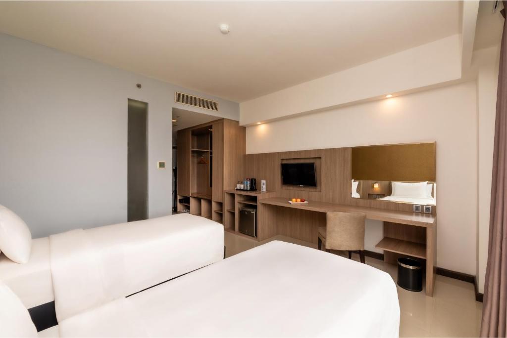 Postel nebo postele na pokoji v ubytování Grand Tan Banjarmasin Hotel & Convention Center