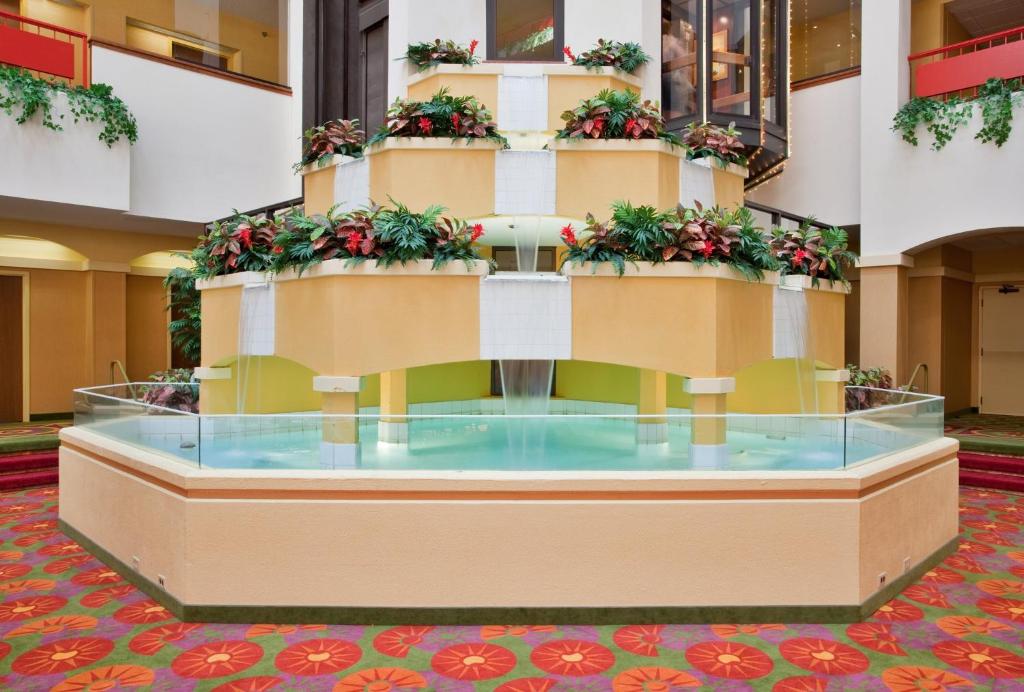 un grand hall doté d'une table en verre avec des plantes dans l'établissement Holiday Inn Hotel & Suites Springfield, an IHG Hotel, à Springfield