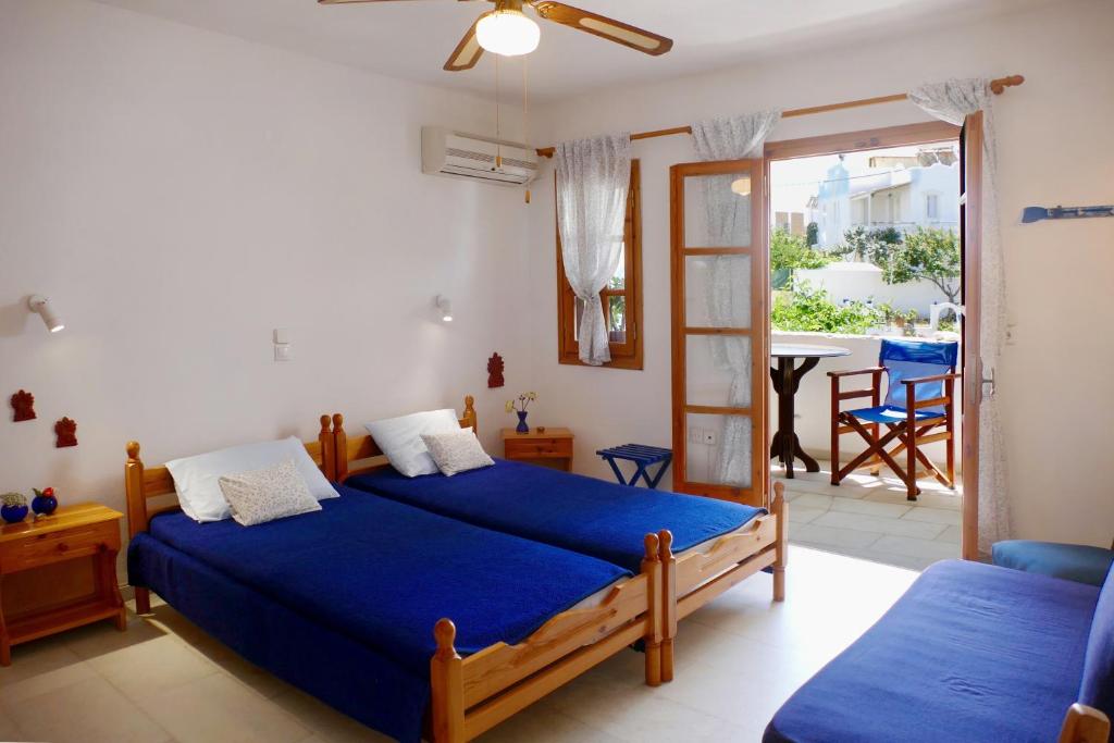 a bedroom with two beds and a balcony at fi naxos in Agios Prokopios