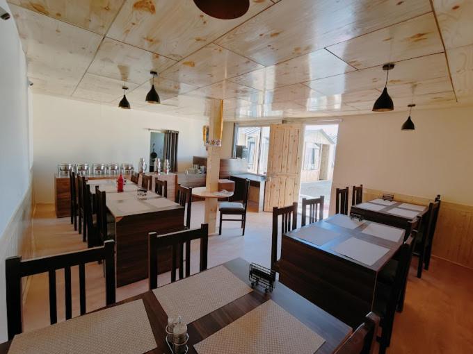 a dining room with tables and chairs in a restaurant at The Grand Lodge Pangong in Lukung