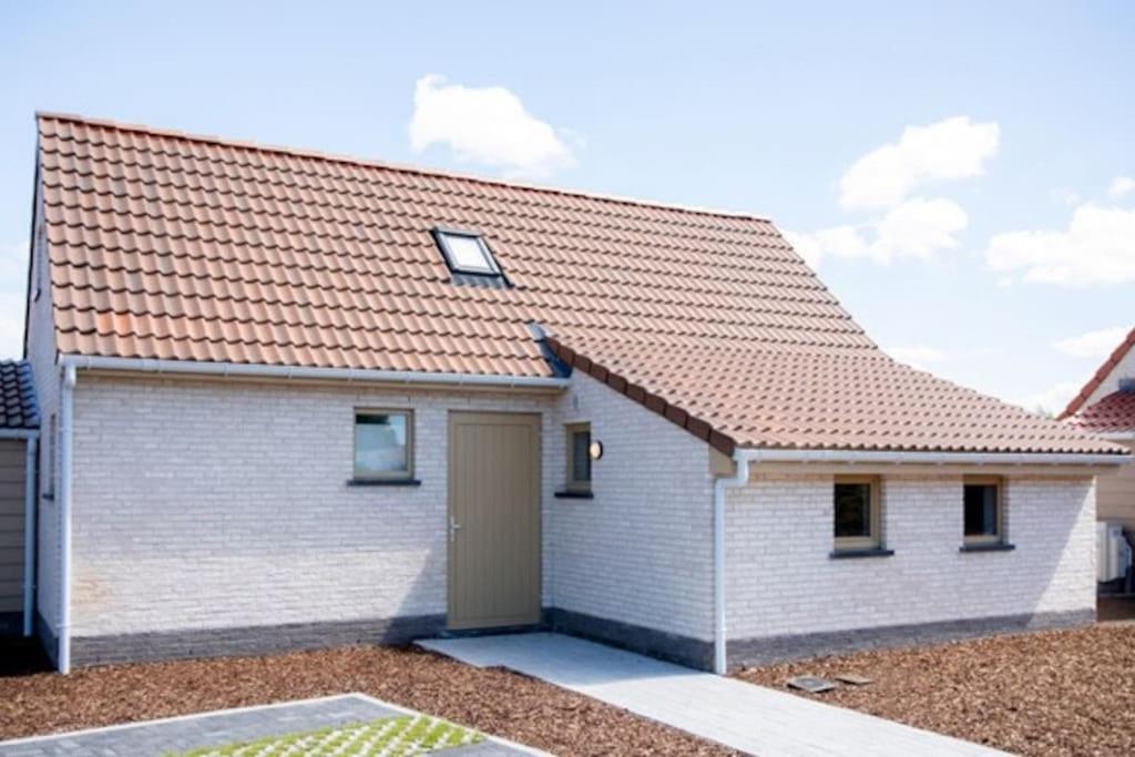 a white brick house with an orange roof at Het Duinenhuisje in Oostduinkerke