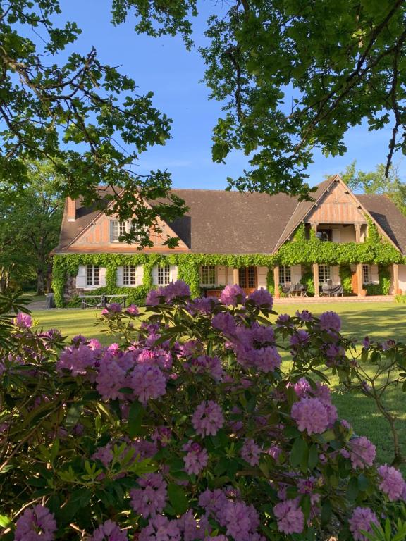 una casa con flores púrpuras delante de ella en Les Vieux Guays, en Cerdon