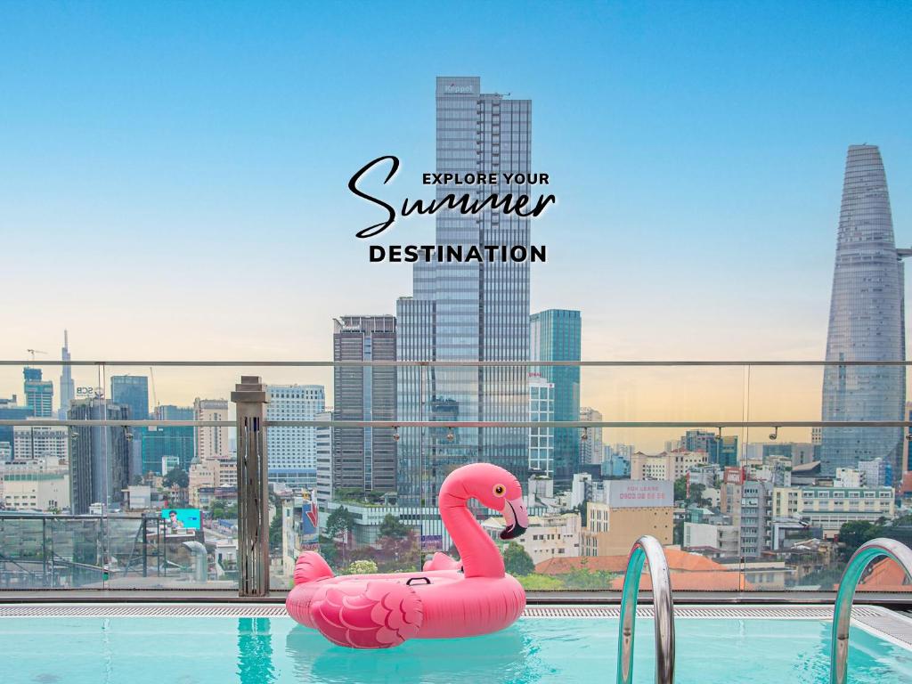 a pink swan float in a pool with a city skyline at Winsuites Saigon in Ho Chi Minh City