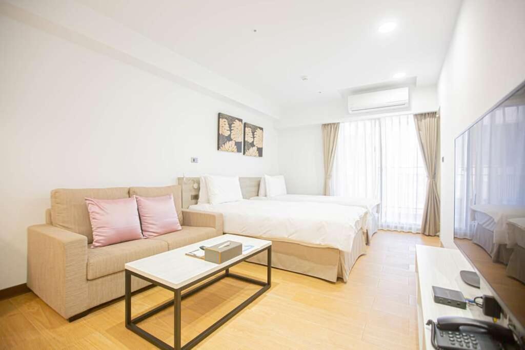 金湖鎮にある金金禮寓Solis hotelのベッド、ソファ、テーブルが備わるホテルルームです。