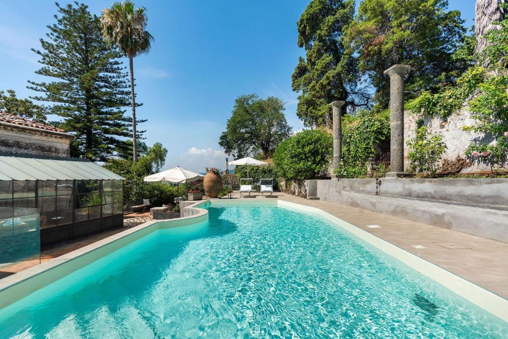 une piscine avec de l'eau bleue dans une cour dans l'établissement Villa Voces, à Catane