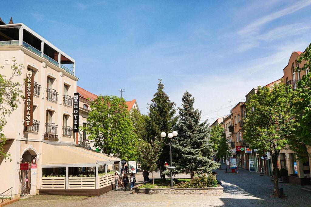 una calle en una ciudad con edificios y árboles en Villa Boutique Hotel en Mukacheve