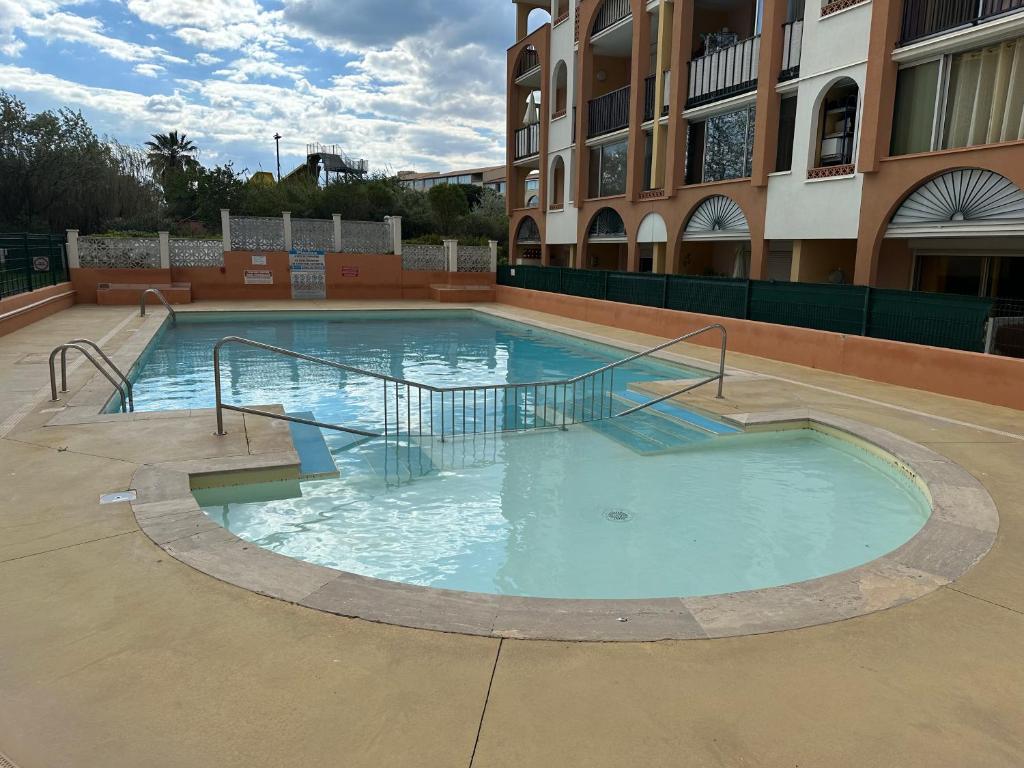 une grande piscine devant un immeuble dans l'établissement Appart:résidence avec piscine, au Cap d'Agde