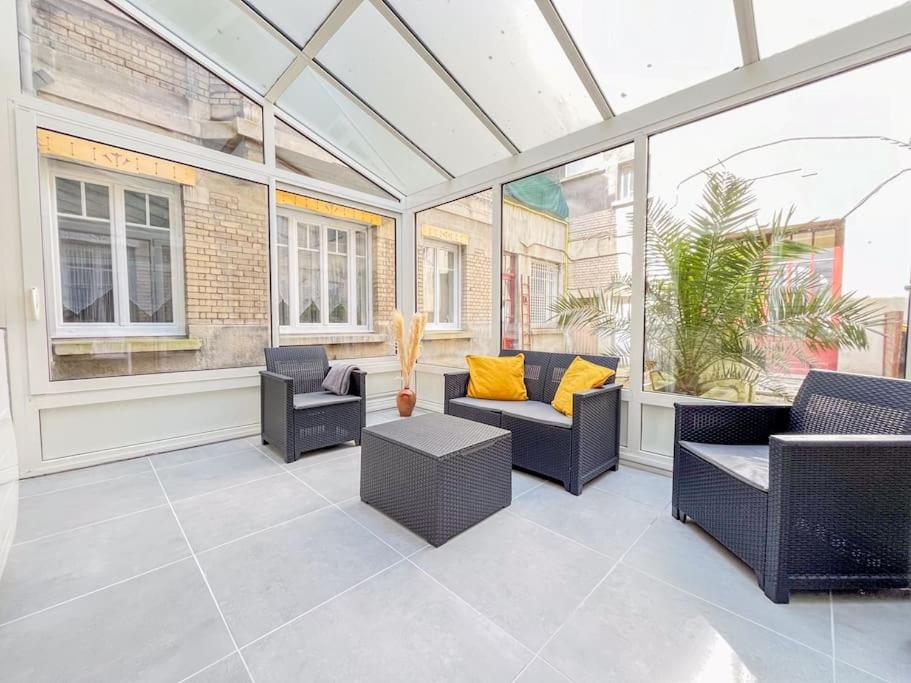 une véranda avec des chaises et des canapés dans une pièce dans l'établissement Le 3 cailloux / 2 Chambre *Hyper centre*, à Amiens