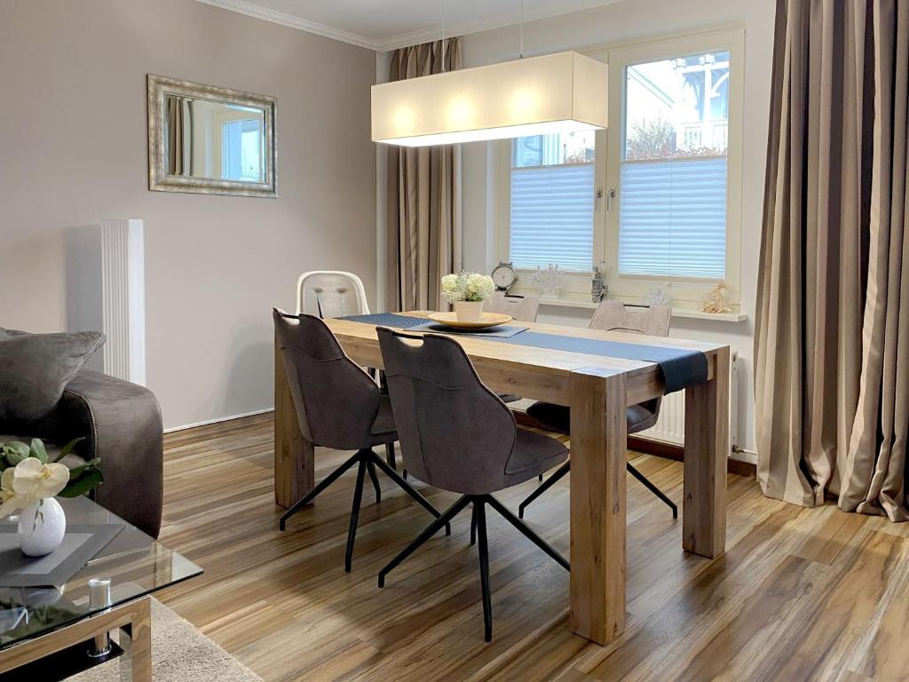 einen Esstisch und Stühle im Wohnzimmer in der Unterkunft Haus "Concordia" in Binz - WG11 "Liuba" mit Terrasse strandnah in Binz