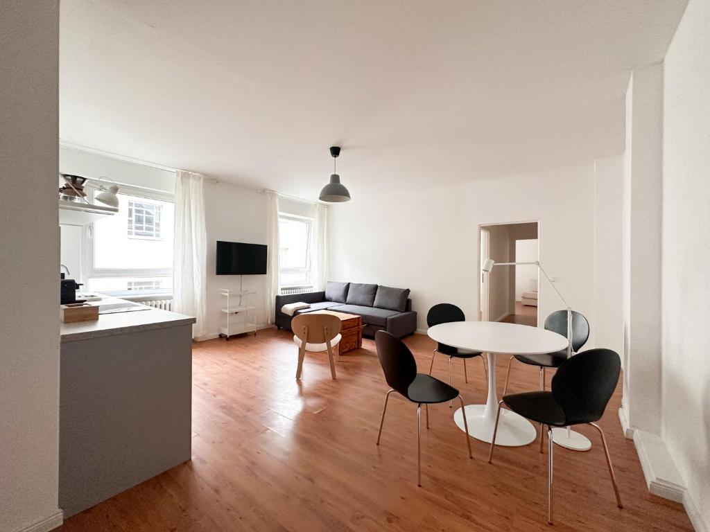 a kitchen and a living room with a table and chairs at NOOK Design Apartments with Kitchen in Berlin