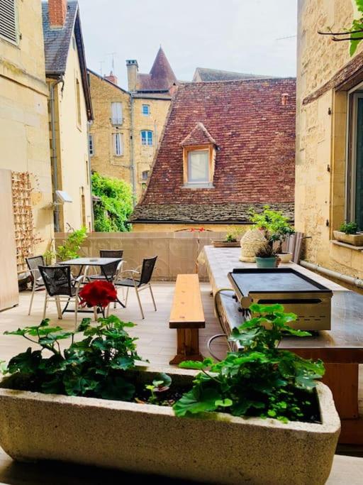 un patio avec une table et des chaises et un oiseau rouge dans l'établissement Appart - Central - Cœur historique, à Sarlat-la-Canéda