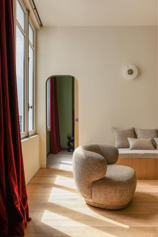 - un salon avec une chaise et un lit dans l'établissement Sublime appartement luxe Paris Haut-Marais AC, à Paris
