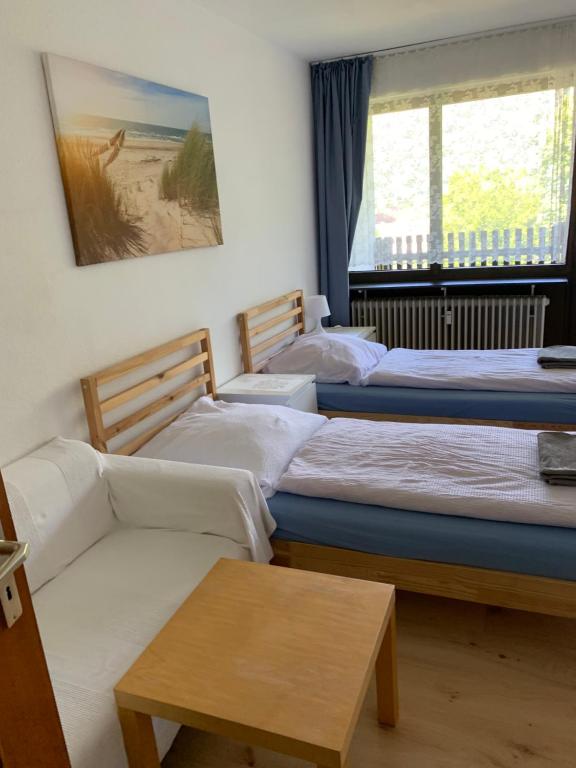 Panoramahaus App 4086 في باد رايشنهال: ثلاثة أسرة في غرفة مع أريكة وطاولة