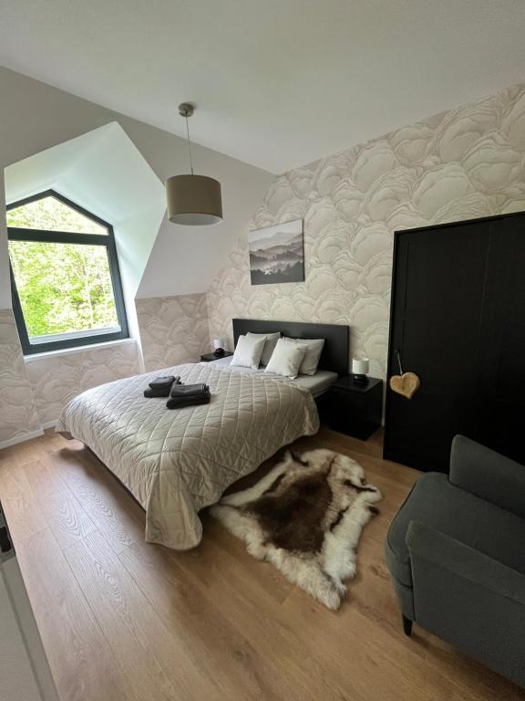 a bedroom with a bed and a couch at JÁNOŠÍK Apartmány in Terchová