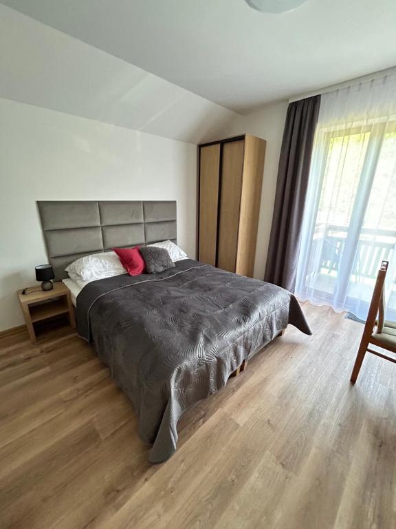 sypialnia z łóżkiem i dużym oknem w obiekcie Wilga Leśne SPA w Solcu-Zdroju