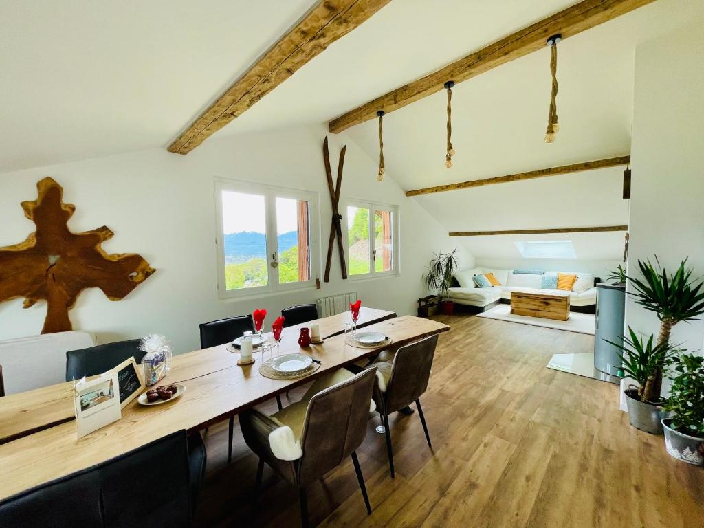 comedor y sala de estar con mesa y sillas en Magnifique appartement Savoie Vue montagne* en Saint-Baldoph
