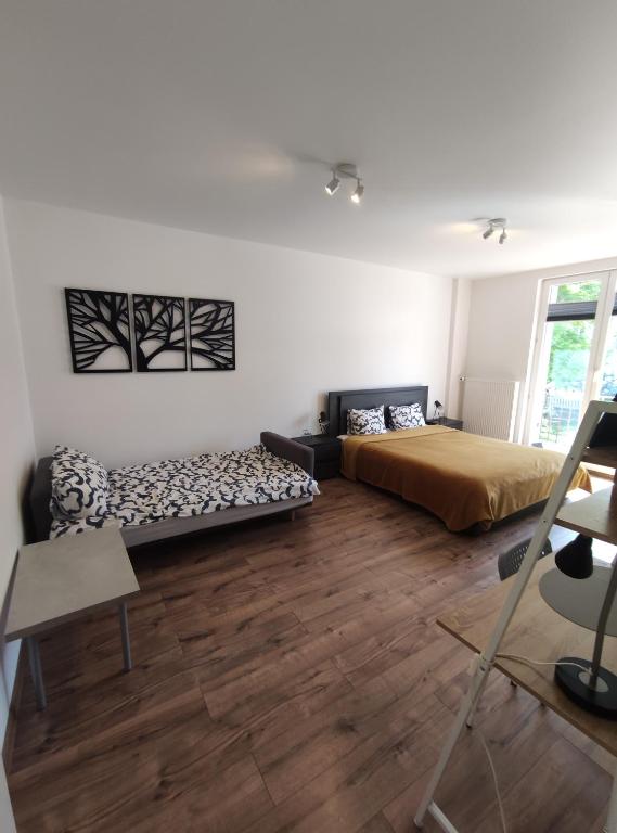 uma sala de estar com duas camas e um sofá em Apartament Wrzosowy Balkon Łódź em Lódź