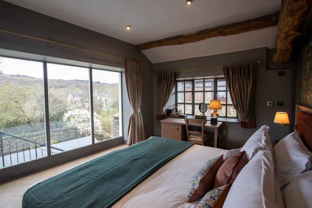 a bedroom with a bed and a desk and a window at Queens Head Inn & Restaurant in Hawkshead