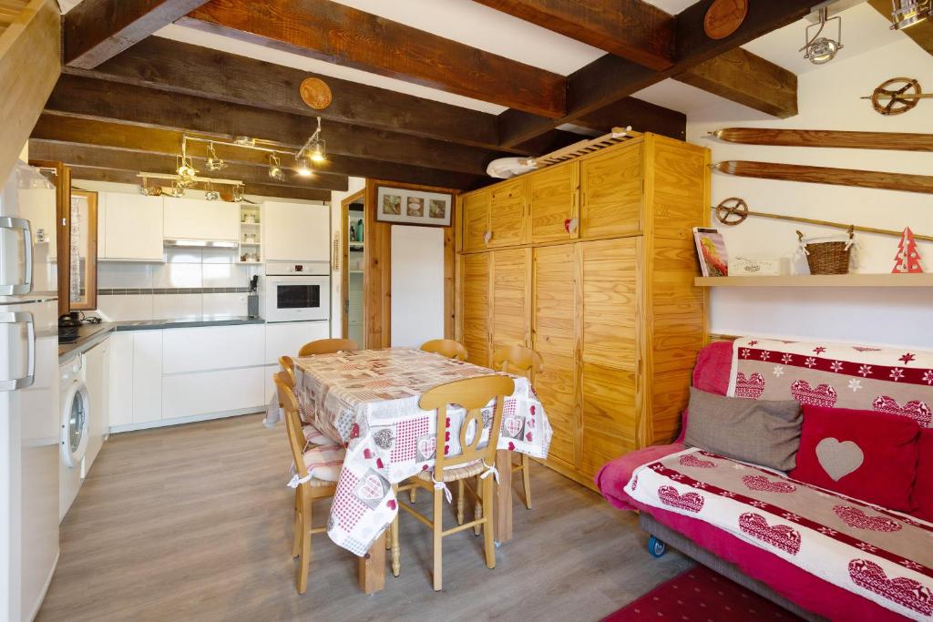 een keuken en eetkamer met een tafel en een bank bij Petit chalet mitoyen Pyrénées 2000 in Font-Romeu