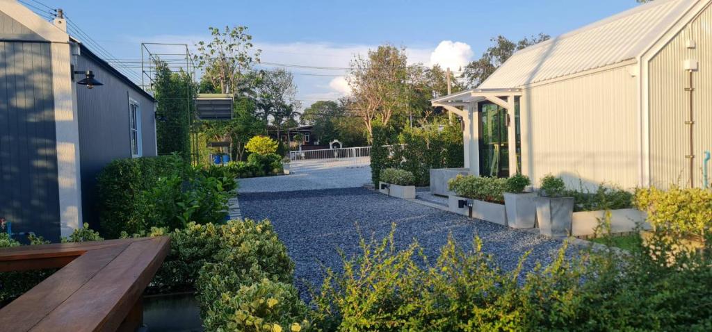 a garden with a wooden bench next to a building at Fill up mini home in Nong Prue