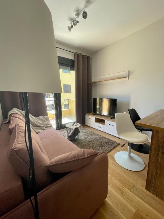 uma sala de estar com um sofá e uma mesa em 1 bedroom cosy apartment em Tivat