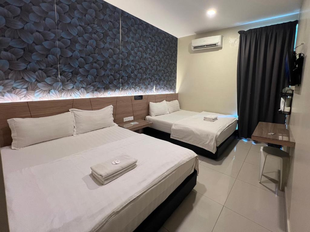 a hotel room with two beds and a wall at Gebeng Industrial Park Budget Hotel in Kuantan