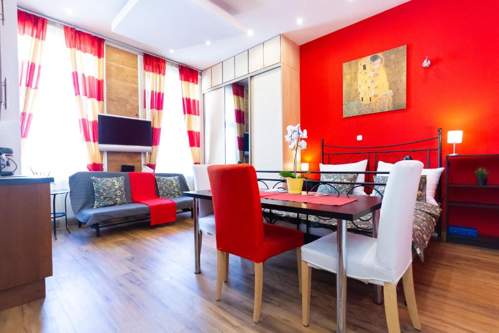 comedor con paredes rojas, mesa y sillas en Badepest Apartment Budapest, en Budapest
