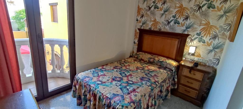 a bedroom with a bed and a dresser and a window at Hotel El Doncel in Atarfe