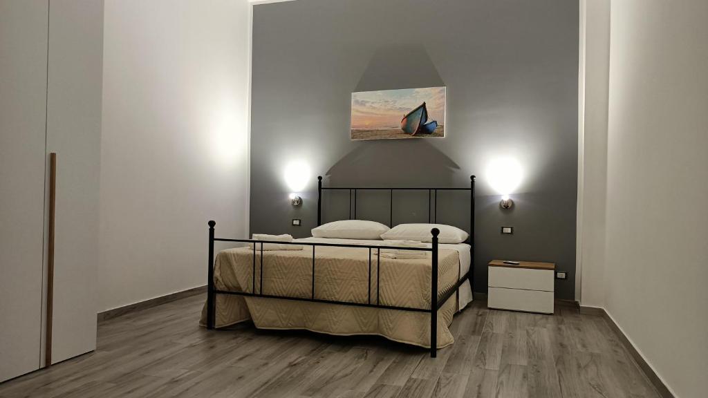 a bedroom with a bed and a painting on the wall at Il tramonto in Balestrate