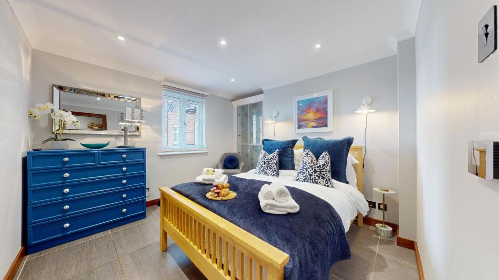 una camera con un letto blu e bianco e un comò blu di Swansea Marina - 3 Bed Apartment - Water Views & Free Parking a Swansea