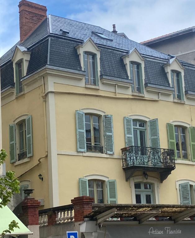 Cette maison jaune dispose de volets verts et d'un balcon. dans l'établissement Villa Baraduc, à Châtel-Guyon