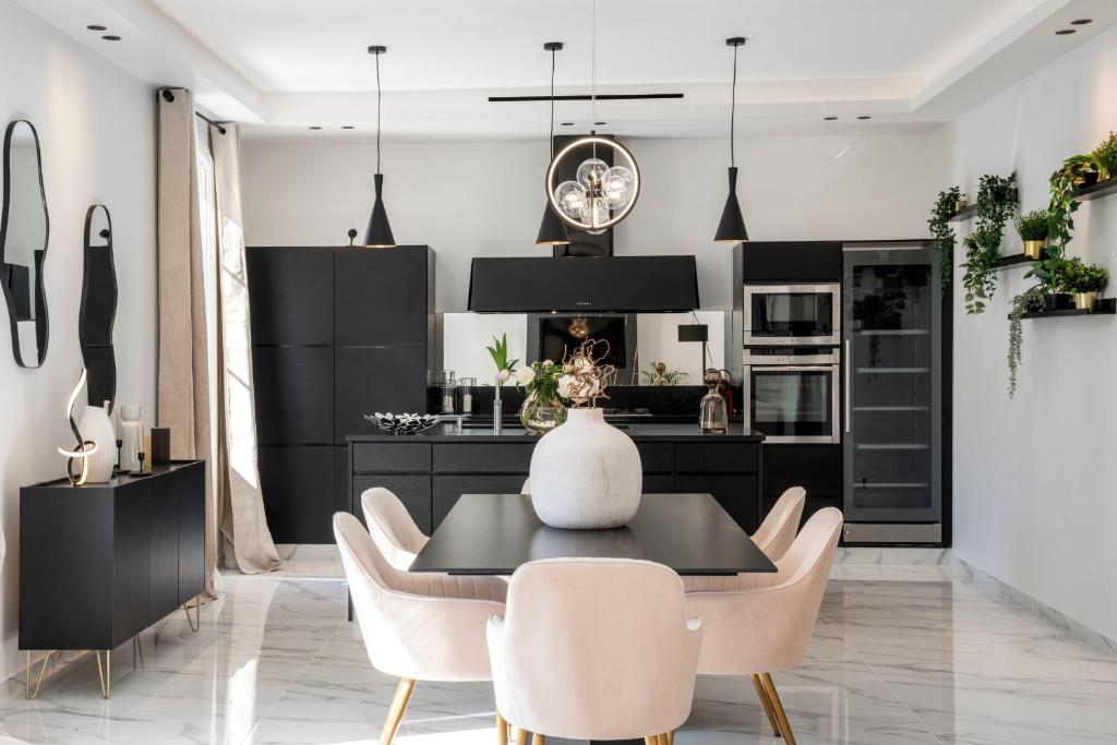 kuchnia z czarnymi szafkami, stołem i krzesłami w obiekcie REF 1466 - Cannes Back Croisette - Penthouse for rent w Cannes