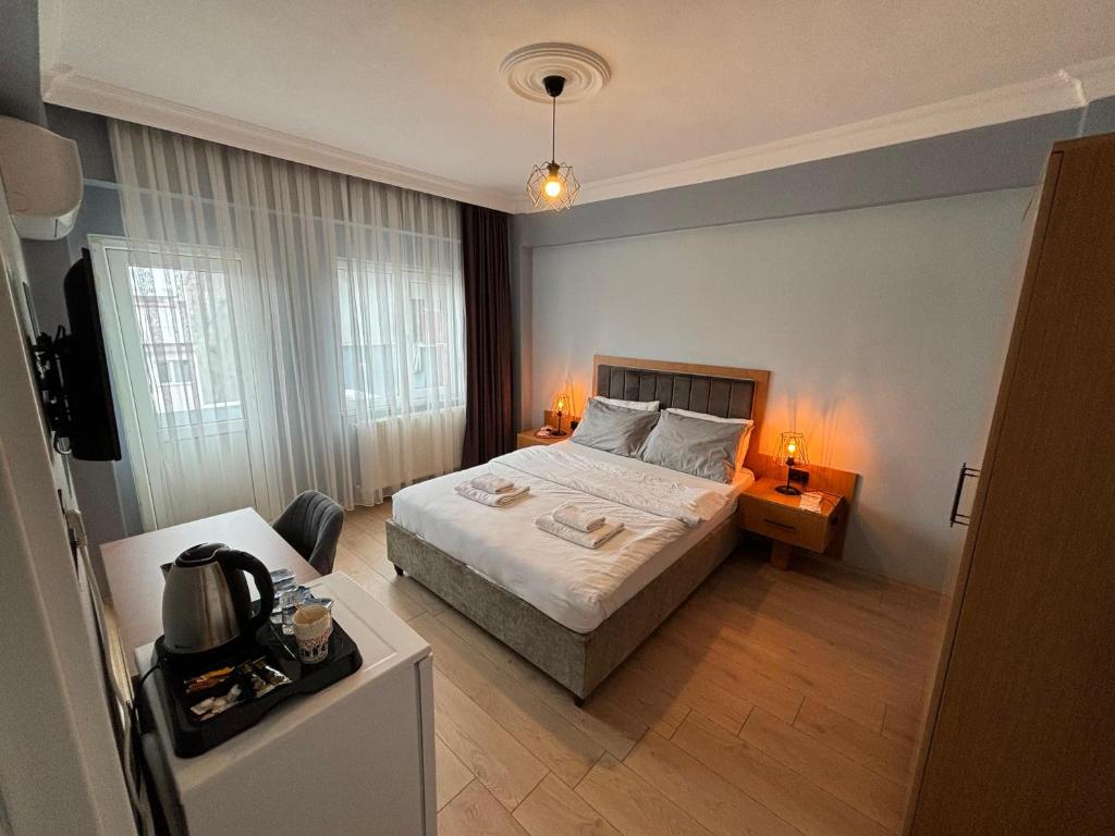 a bedroom with a bed and a desk with two lamps at ÇOLAK SUIT in Arsin