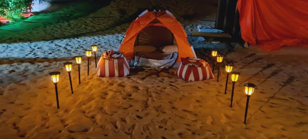 Hunaywah的住宿－Royal Desert Tourism LLC，一组在沙子里的蜡烛和帐篷
