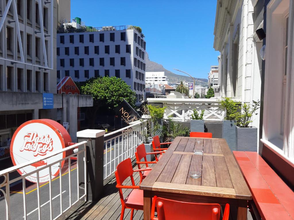 a wooden table and chairs on a balcony at Daddy Long Legs Art Hotel in Cape Town