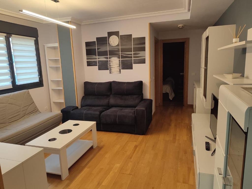 - un salon avec un canapé et une table dans l'établissement Apartamento Florida-Natura Oviedo, à Oviedo