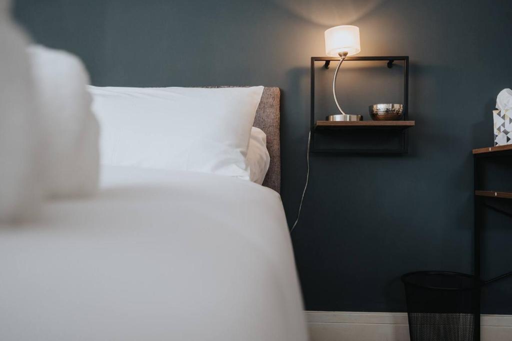 リバプールにあるWoolton Rd Flat Near John Lennon Airport, Free Parking & Wifi - Pass the Keysのベッドルーム1室(白い枕とランプ付きのベッド1台付)