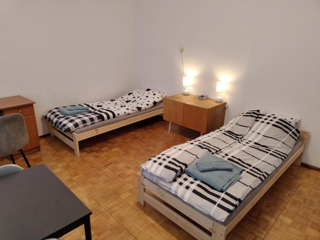 um quarto com 2 camas, uma secretária e uma mesa em Apartament Centrum em Kalisz