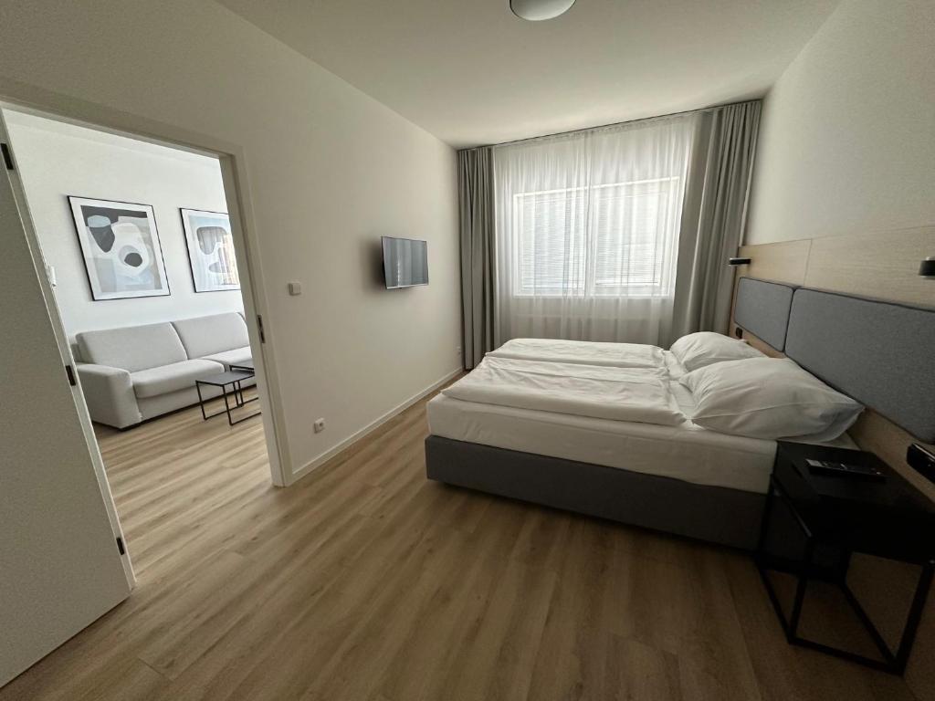 een slaapkamer met een bed en een woonkamer bij Hotel Kapitol in Most