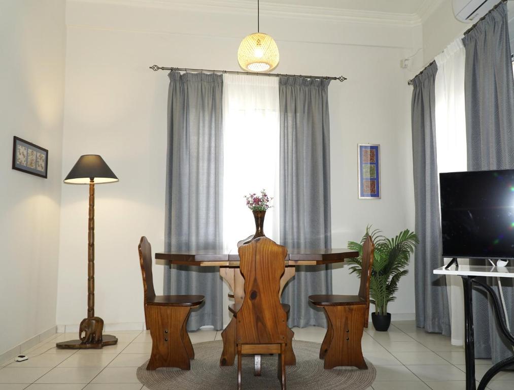 una sala da pranzo con tavolo, sedie e TV di Elegant central apartment a Heraklion