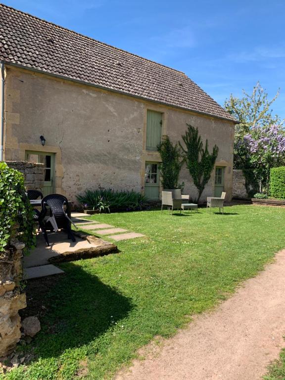 een huis met een tuin met stoelen en een gebouw bij Gîte de la Grange in Colombiers
