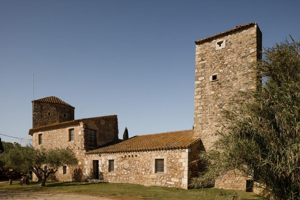 an old stone building with a tower at Castell de Vallgornera in Girona