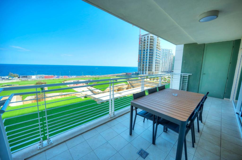 a balcony with a table and a view of the ocean at Fort Cambridge Apartments in Sliema