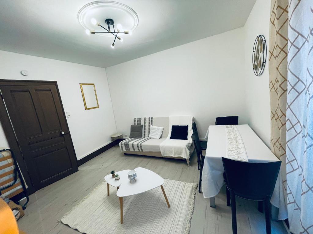 une petite pièce avec un lit et une table dans l'établissement Thé Pékin, à Belfort