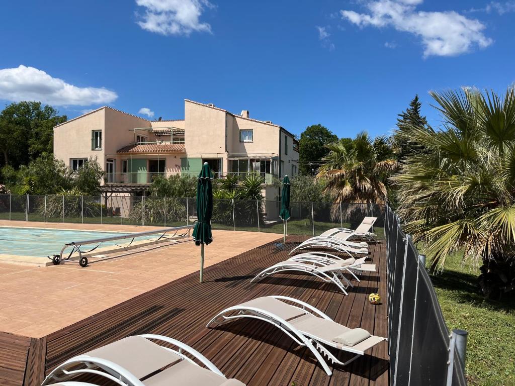 a row of lounge chairs next to a swimming pool at MAS Élancia in Argelès-sur-Mer
